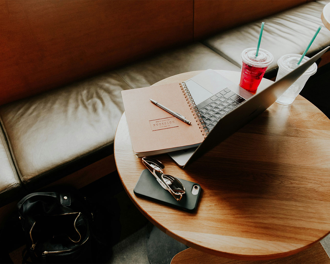 A laptop placed beside a cup of coffee on a café table, with soft natural light and a relaxed atmosphere suggesting a productive yet cosy work moment.