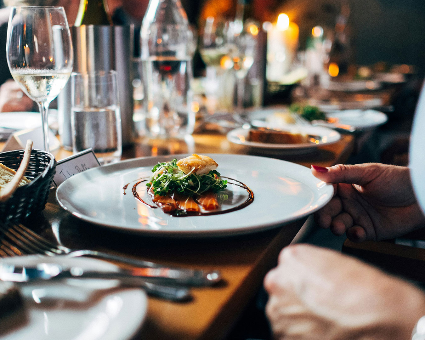 A beautifully plated main dish placed on a wooden restaurant table, with warm lighting and tableware creating a cosy dining atmosphere.