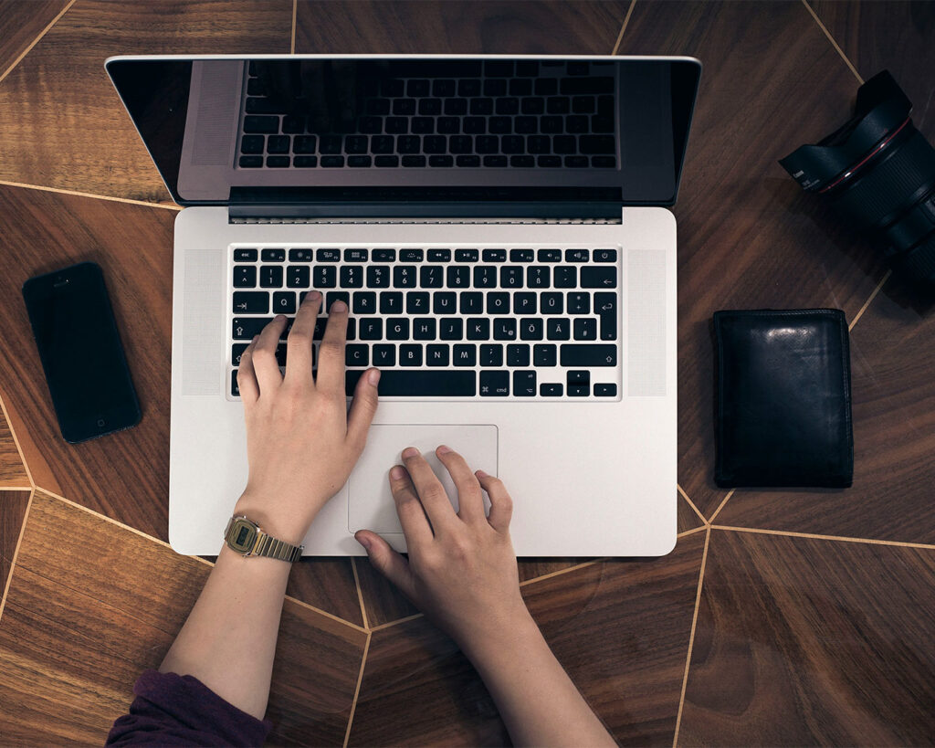 A close-up view of a hand typing on a laptop keyboard, symbolising focused work, productivity, and digital communication in progress.