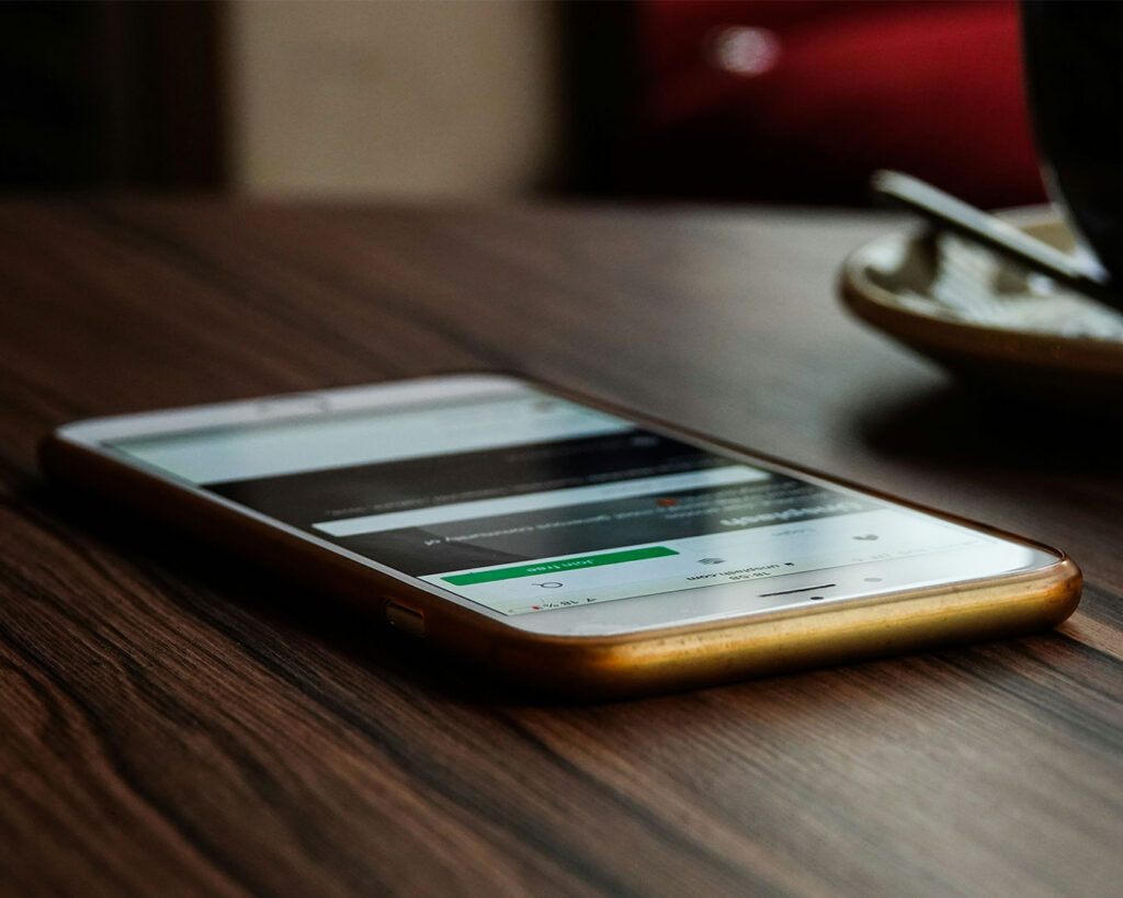 A smartphone resting on a table surface, positioned as if ready for use or waiting for a notification.