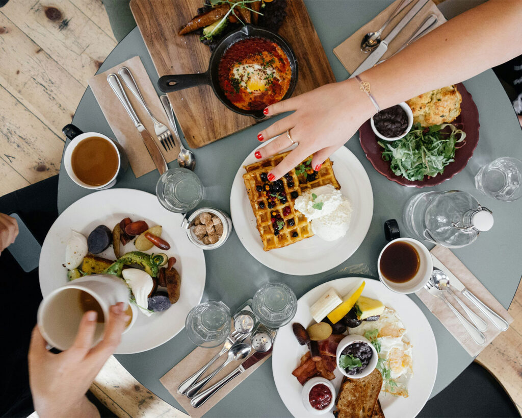 A table filled with different dishes, showing a wide selection of food prepared for sharing or group dining.
