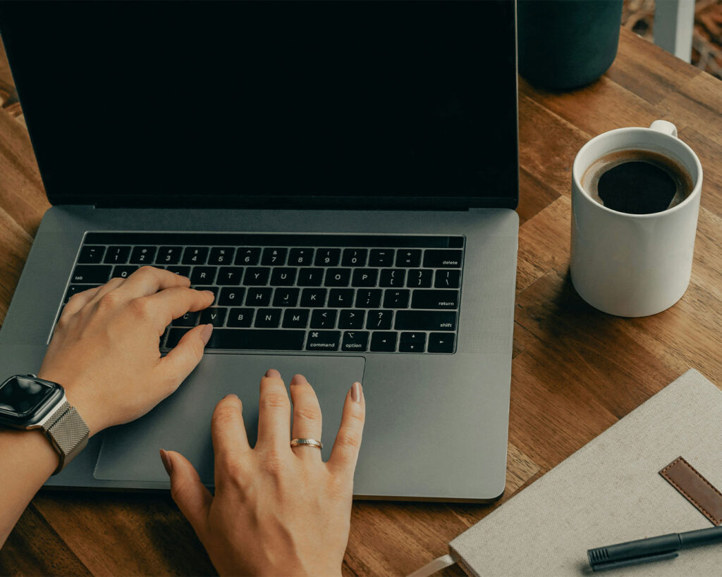 A hand opening a laptop, symbolising the start of work, study, or digital activity.